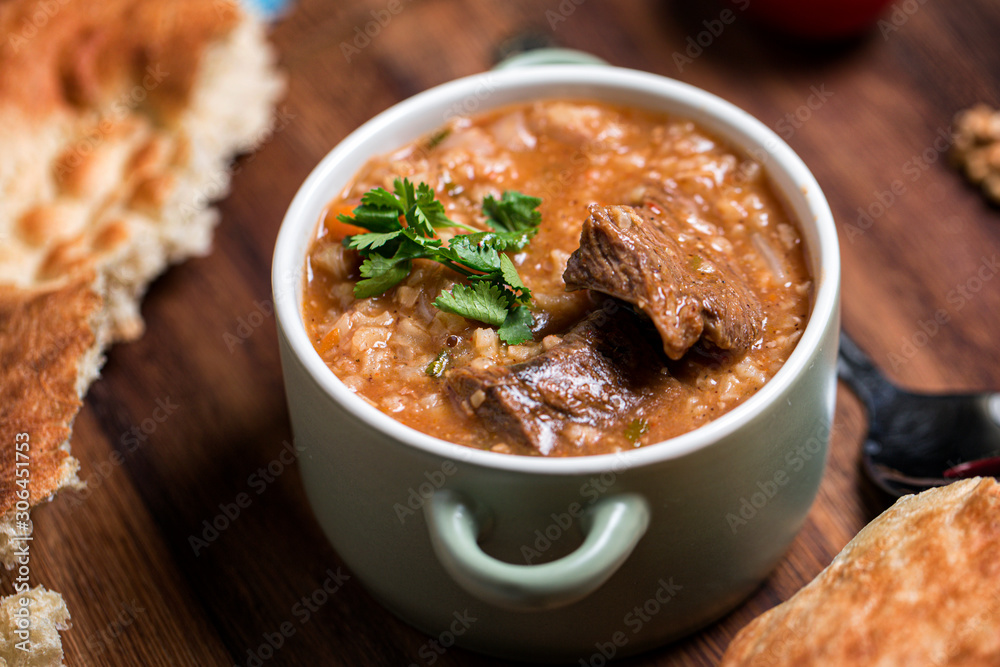 Kharcho soup with lamb meat served in a clay bowl with lavash flatbread Kharcho soup with lamb meat served in a clay bowl with lavash flatbread