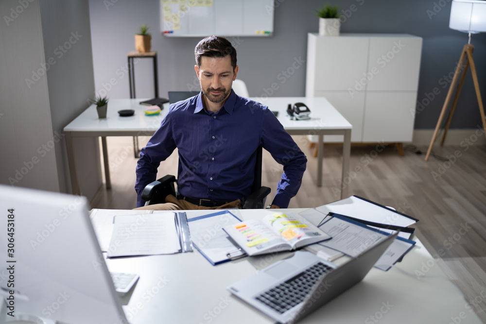 Businessman Sitting On Wheelchair In Office Businessman Sitting On Wheelchair In Office