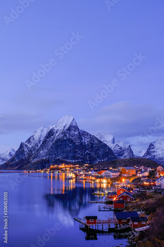 Reine, snow covered mountains in the background and the fishing cabins Rorbu in the foreground, Lofoten Islands, Norway © reisegraf