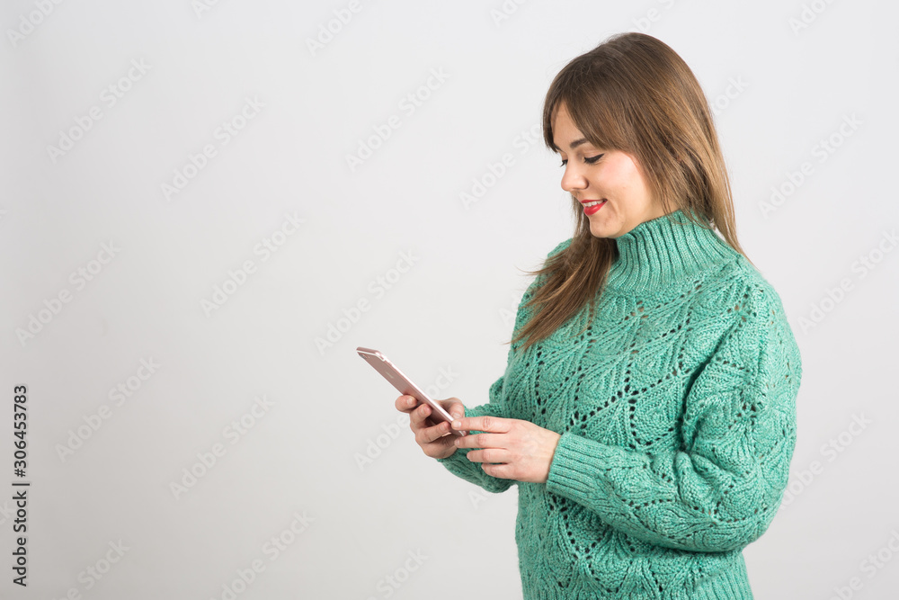 girl with green sweater using mobile phone in an isolated space girl with green sweater using mobile phone in an isolated space
