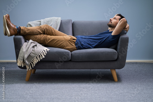 Man Relaxing On Sofa At Home photo