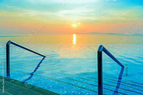 Swimming pool with stair and sunset background © opasstudio