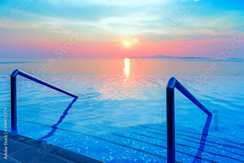 Swimming pool with stair and sunset background © opasstudio