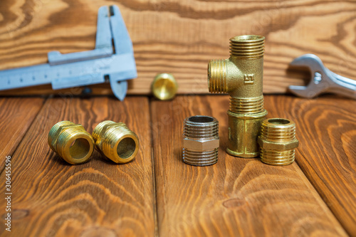 Set of brass fittings is often used for water and gas installations on background of tools