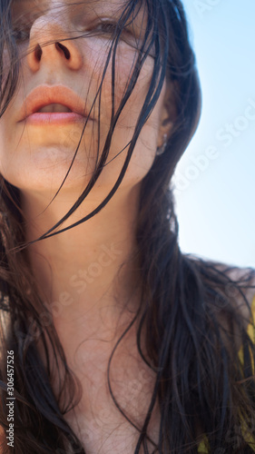 Vacation at the sea, young woman with wet hair after swimming, close-up portrait.