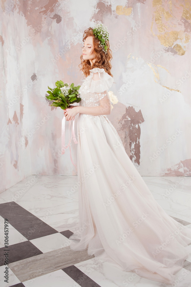 Portrait of a young beautiful woman in wedding dress with wreath and bouquet of fresh flowers. Portrait of a young beautiful woman in wedding dress with wreath and bouquet of fresh flowers.