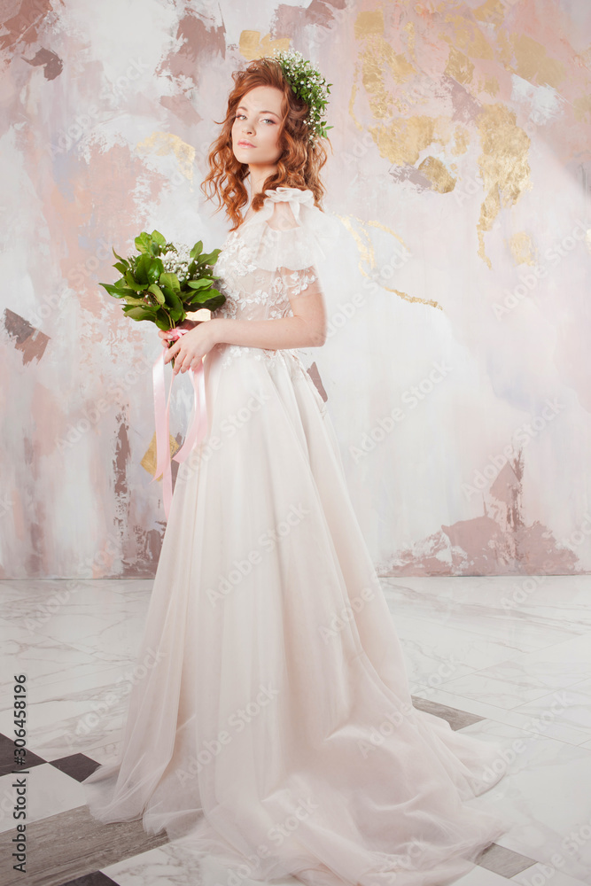 Portrait of a young beautiful woman in wedding dress with wreath and bouquet of fresh flowers. Portrait of a young beautiful woman in wedding dress with wreath and bouquet of fresh flowers.