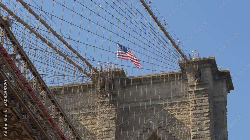 Zoom into American Flag on top of Brooklyn Bridge Tower underneath beautiful clear sky Zoom into American Flag on top of Brooklyn Bridge Tower underneath beautiful clear sky