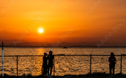 江川海岸で夕日を見る人々 © にっし～