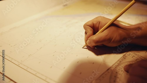 Closeup shot of marine navigational officer during navigational watch on Bridge . He does chart correction of nautical maps and publications. Work at sea photo