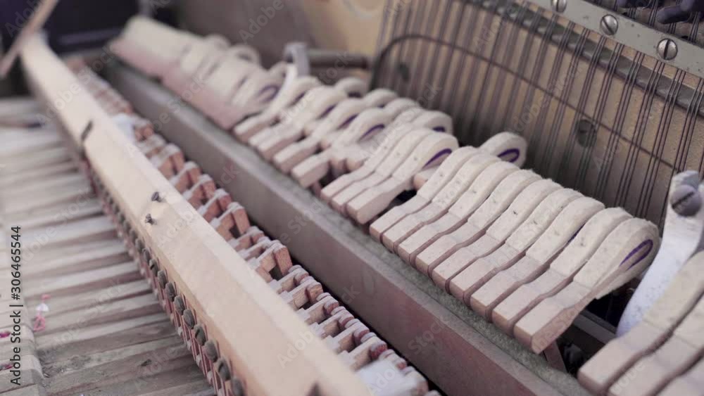 Closeup of Old Dusty Piano Hammers Hitting Strings