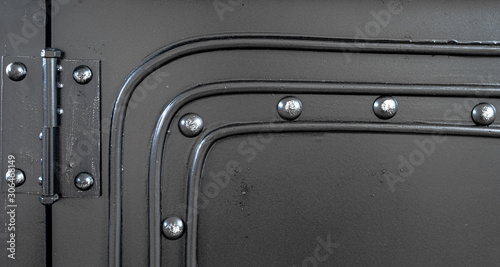 Black metallic background with hinge and metal rivets. 