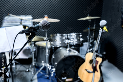 Professional condenser studio microphone, Musical Concept. recording,microphone in radio studio, selective focus microphone and blur musical equipment guitar ,bass, drum piano background.