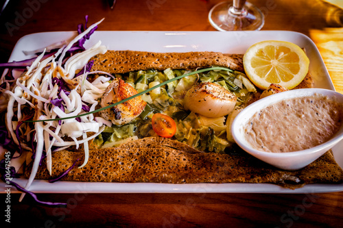 Traditional Galette bretonne with scallops from Brittany, France. Breton galettes are pancakes made with buckwheat flour usually with a savoury filling and popular in Bretagne.