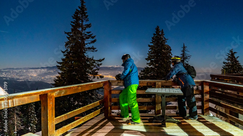 Poiana Brasov, Romania. Postavarul Peak. Panorama of a groomed snow and forest ski in winter resort. Dark scenery at night long exposure. photo