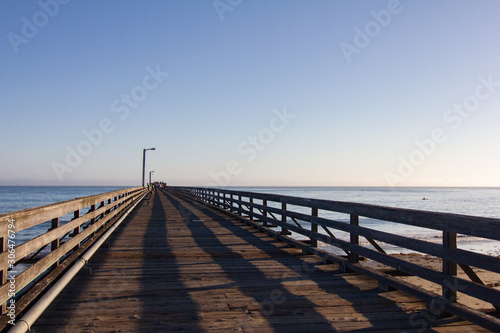Long Wooden Pier with Shadows and Ocean During Dusk © Laura Rachfalski
