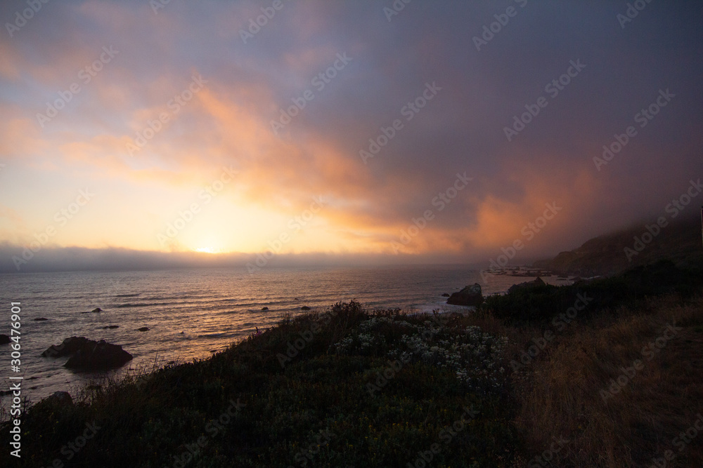 Colorful Sunrise over Pacific Ocean with Flowering Grassy Cliff