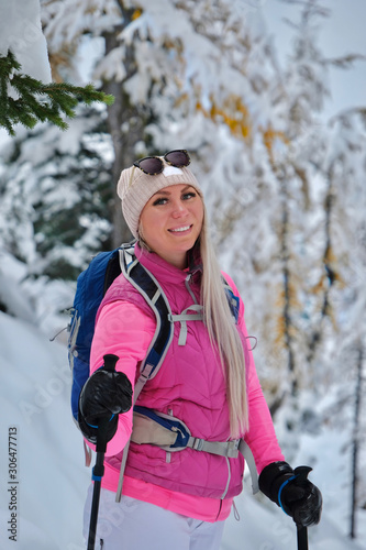 Portrait of a young smiling active woman with green eyes in winter sporty clothes hiking in snowy forest.  Canadian Rockies. Banff National park.  Lake Louise area. Alberta. Canada photo