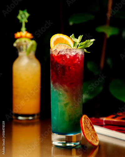 ombre cocktail garnished with orange and lime slices
