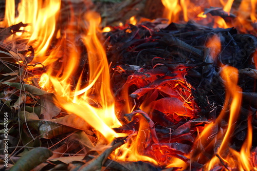 Orange color fire flame and black smoke from burning sticks , Bonfire with combustion air pollutant, Firewood and garbage are burning