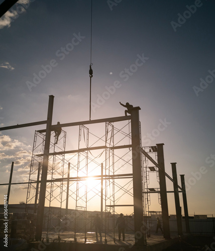 welder is working on top of column, process before install metal sheet siding, connecting plate on ground, photo is Flare filter, picture is portrait style photo
