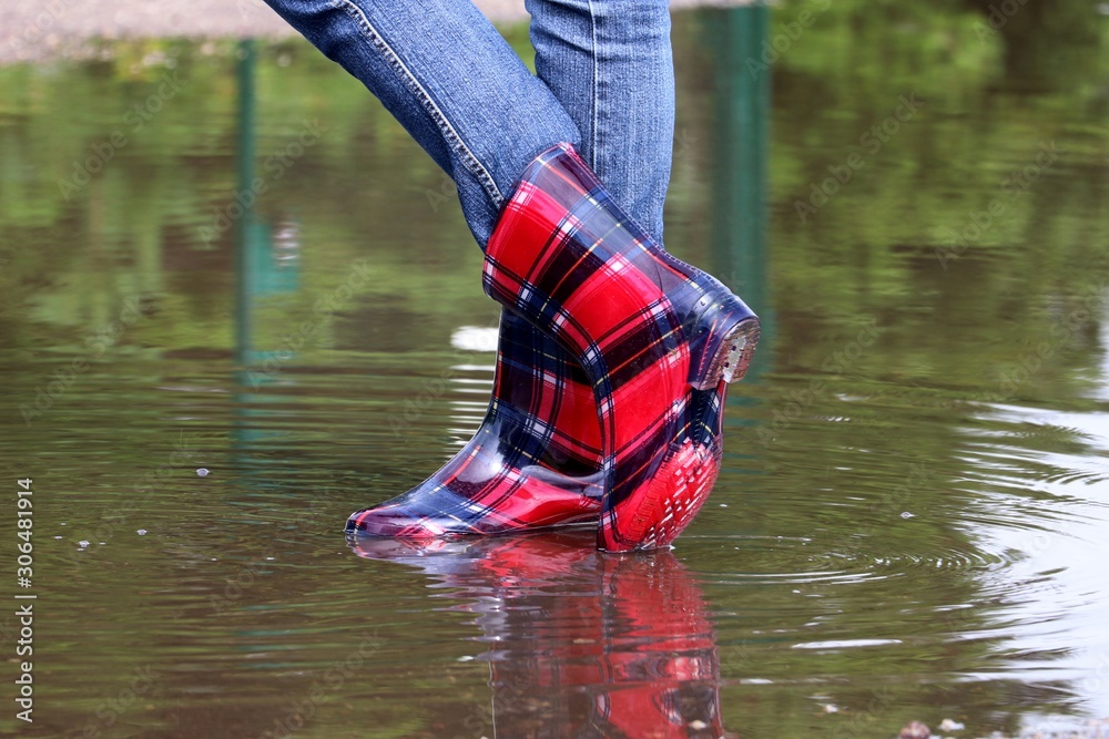 Human feet in rubber boots in Puddle of water Photos | Adobe Stock