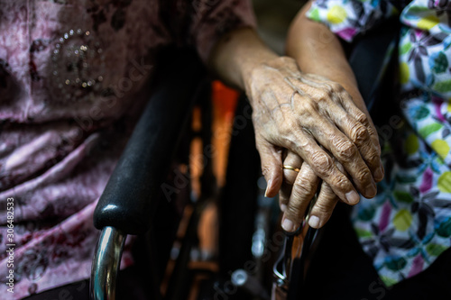 Asian senior people and old friends in wheelchair,holding hands to encourage each other in times of discouragement and despair,elderly care,support,compassion and understanding,friend,true friendship