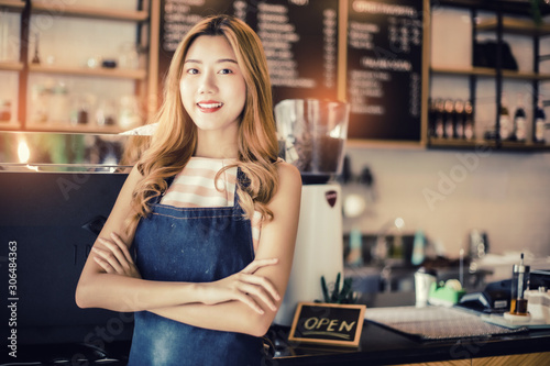 Portrait young Asian woman barista feeling happy smiling at urban cafe. Small business owner Korean girl in apron relax toothy smile