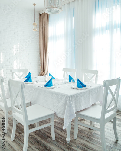 restaurant room with white table and chairs and blue napkins © Kamran