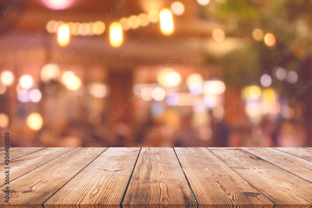 Wood table top with blurred light bokeh in restaurant background