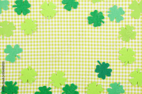 Flat lay Happy St. Patrick s background mockup of handmade felt shamrock clover leaves on green napkin