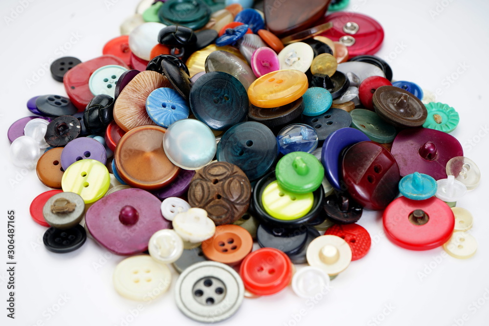 Many different buttons on a light background. Selective focus. Home needlework Many different buttons on a light background. Selective focus. Home needlework