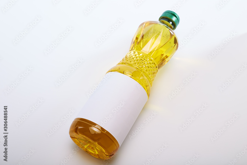 Fototapeta premium Vegetable oil in plastic bottle on white
