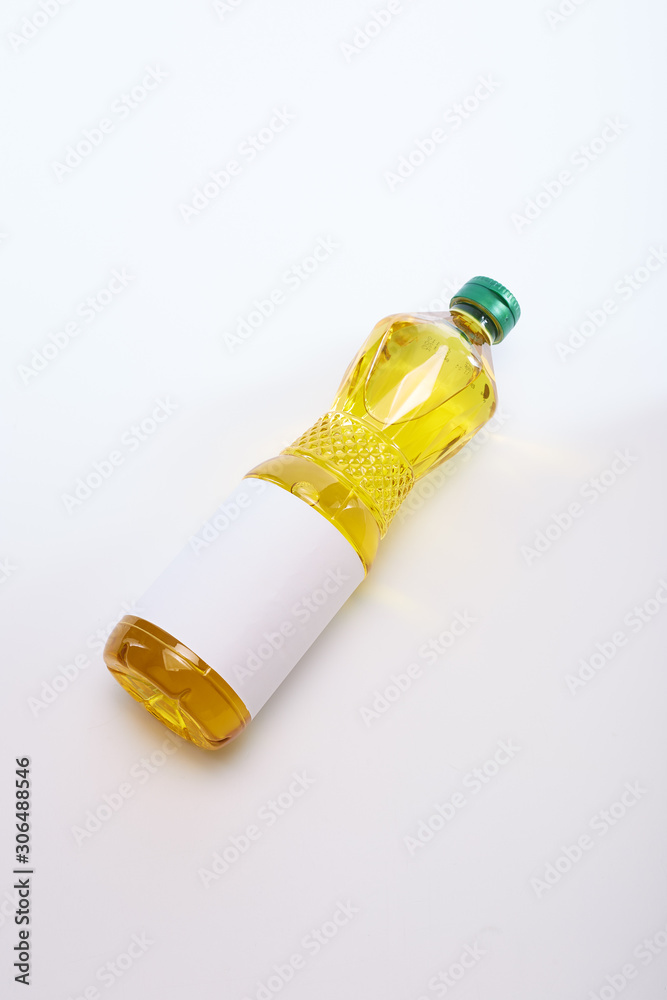 Fototapeta premium Vegetable oil in plastic bottle on white