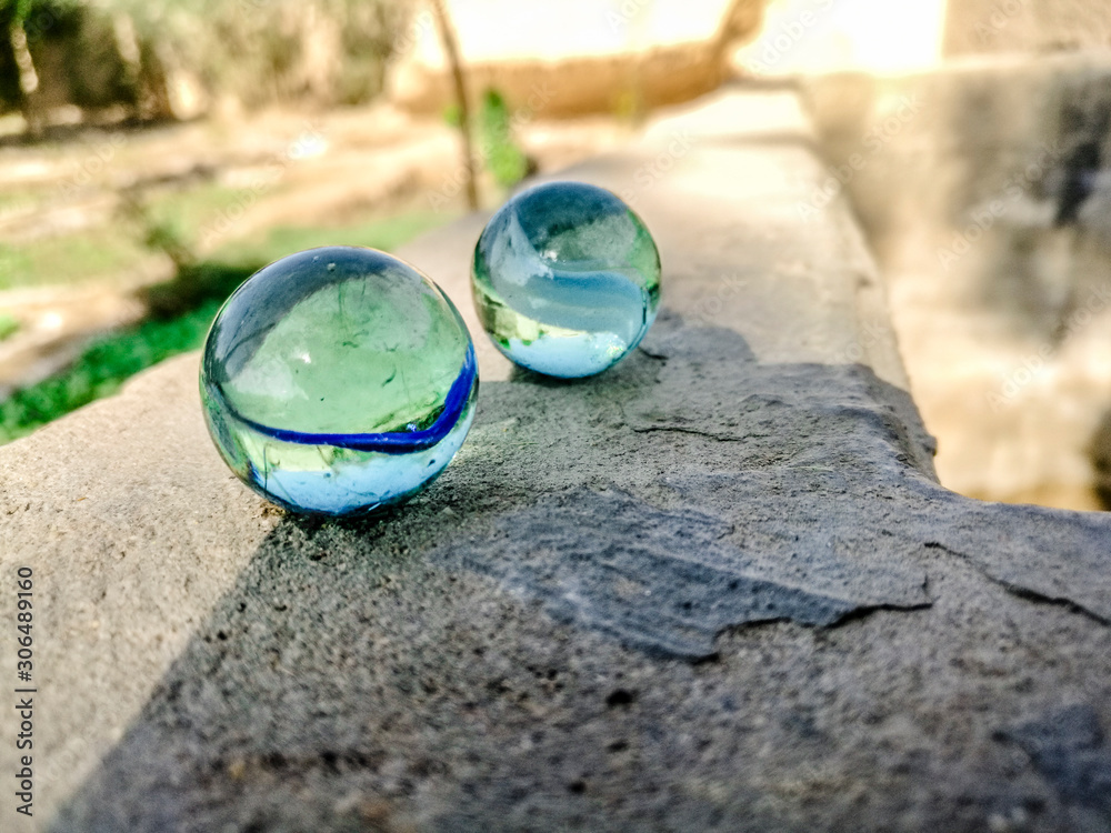 small crystal balls kept on a concrete floor Stock Photo | Adobe Stock