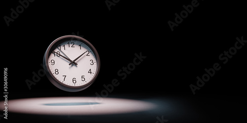 Clock Spotlighted on Black Background