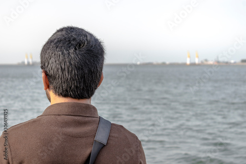 a man is standing at front of sea after being divorced and feeling so lonely and sad