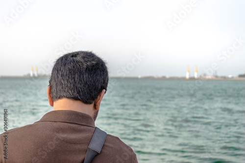 a man is standing at front of sea after being divorced and feeling so lonely and sad
