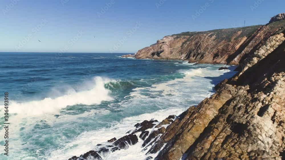 Aerial - Flying from rocky coastline over heavy waves crashing into sheer cliffs, The Point Mossel Bay Aerial - Flying from rocky coastline over heavy waves crashing into sheer cliffs, The Point Mossel Bay