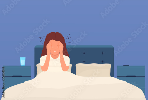 Headache. A woman in bed has a headache, migraine, pressure in the head. Tired girl with severe pain in temples presses hands to head.