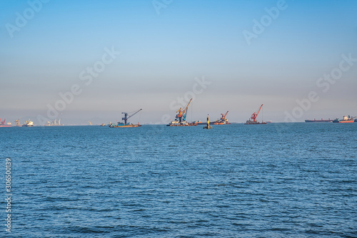 Floating cranes and container ships off the Pearl River Estuary, Guangdong, China