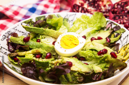 lettuce, avocado and pomegranate salad, diet and health concept