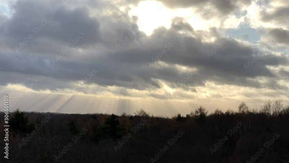 Clouds moving fast with high wind and the sunlight passes through down in straight lines Clouds moving fast with high wind and the sunlight passes through down in straight lines