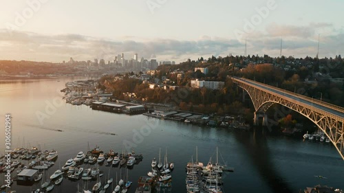 Drone Aerial Push past Aurora Bridge on Lake Union with Seattle Skyline in background and lake rowers. During sunrise. Fremont, Seattle, WS