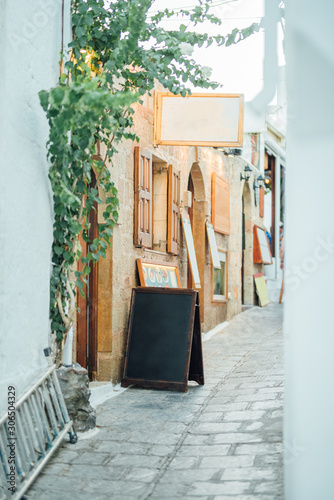 Fototapeta Naklejka Na Ścianę i Meble -  Tight street paved with stones with shops and cafes in the Lindos village