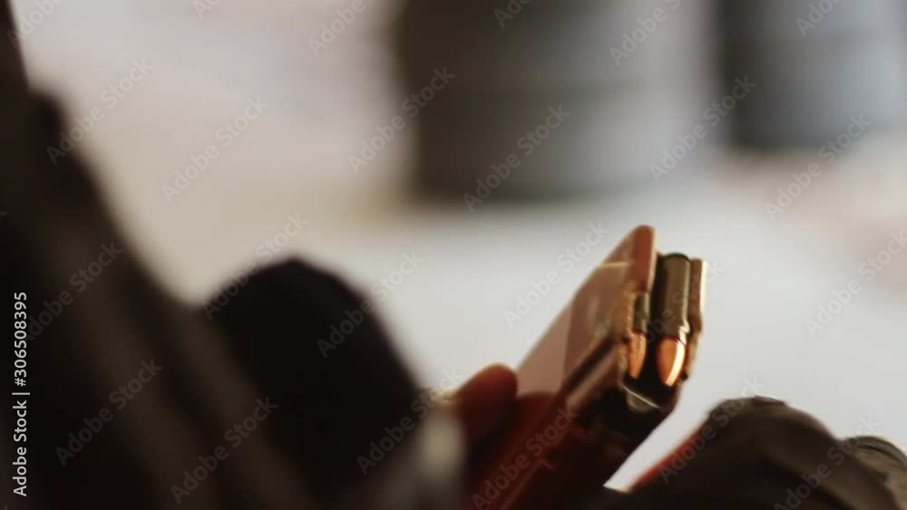 Male hands insert live ammunition into an assault rifle magazine. close-up, HD, no sound Male hands insert live ammunition into an assault rifle magazine. close-up, HD, no sound