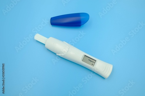 Digital pregnancy test with weeks estimator over blue background