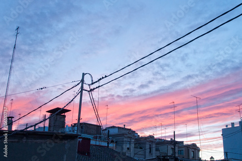  sky with clouds at sunset with silhouettes of cables and terraces of buildings