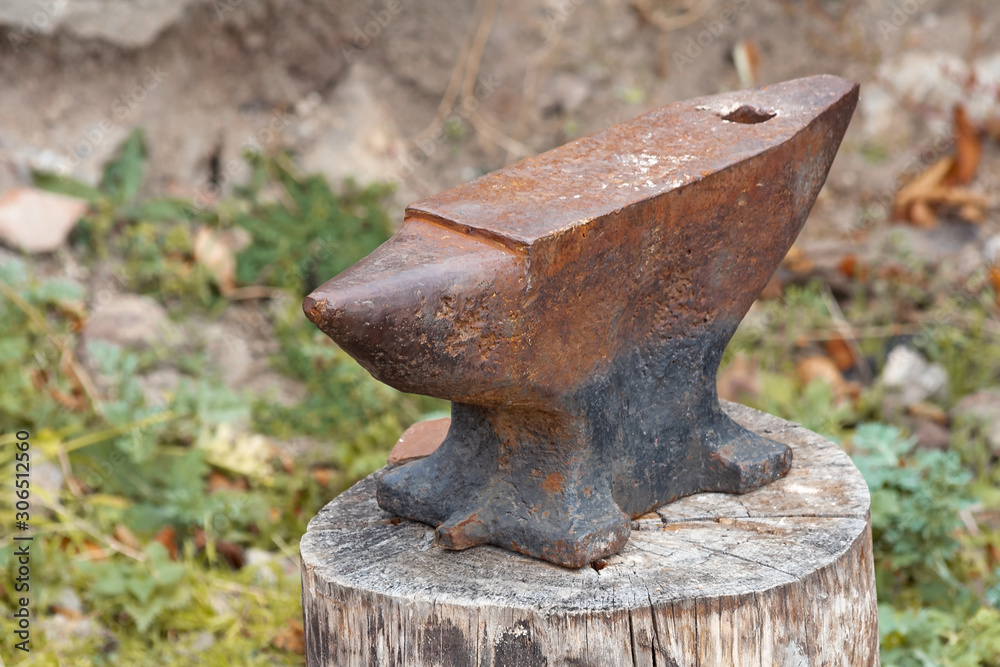 Old rusty anvil on a wooden stump. Blacksmith, metalsmith, farrier tools. Close view. Old rusty anvil on a wooden stump. Blacksmith, metalsmith, farrier tools. Close view.