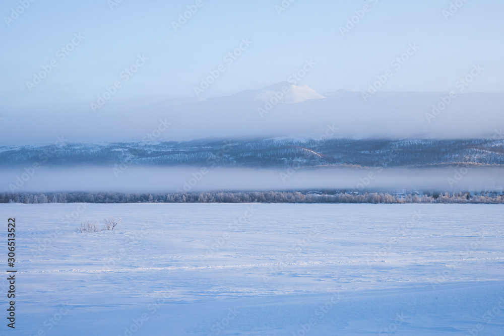 foggy morning over a frozen lake in sweden